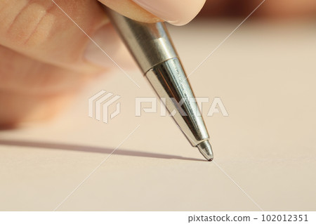 Hand of woman holding iron ball-pen ready to write notes 102012351