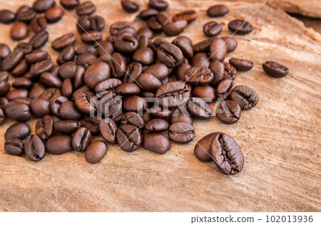 Coffee beans on wooden table background Coffee beans on wooden table background 102013936