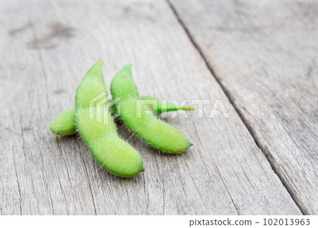 Fresh green soybeans on wooden background 102013963