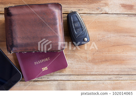 Smart phone,wallet,passport and car key on wooden table Smart phone,wallet,passport and car key on wooden table 102014065
