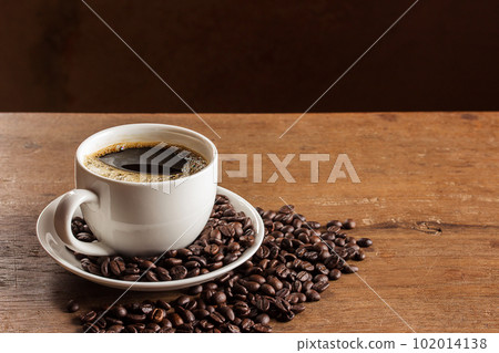 Coffee cup and coffee beans on table 102014138