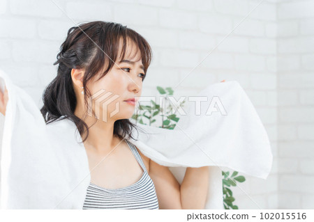 Asian woman after bath suffering from itchy scalp, dandruff and odor Asian woman after bath suffering from itchy scalp, dandruff and odor 102015516