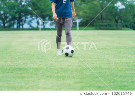 Feet of a woman dribbling a soccer ball 102015746