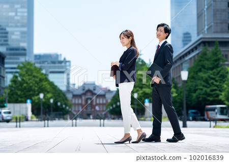 Male and female businessmen in suits working in an office district 102016839