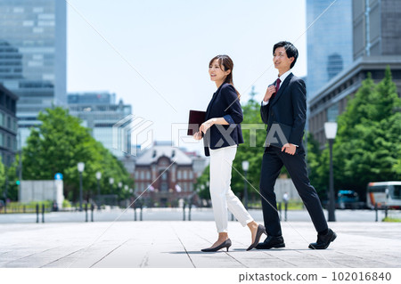 Male and female businessmen in suits working in an office district 102016840
