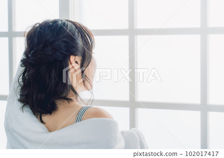 一位亞洲女性洗完澡後用毛巾擦乾頭髮的背影 102017417