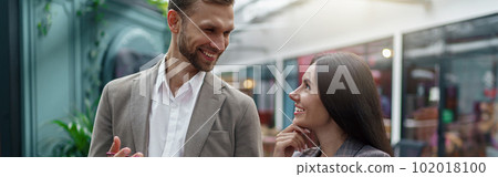 Two business people talking while standing in office during break. Teamwork concept Two business people talking while standing in office during break. Teamwork concept 102018100