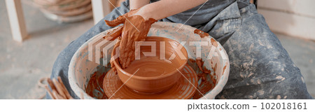 Young woman works on pottery wheel in atelier Young woman works on pottery wheel in atelier 102018161