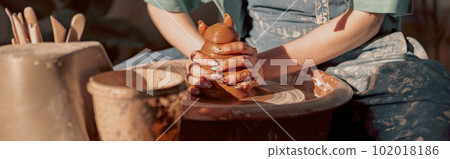 Clay artist modeling product on potter wheel in workshop 102018186