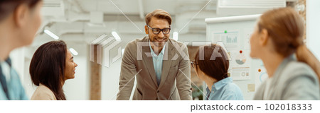 Happy man talking to his female colleague during a meeting Happy man talking to his female colleague during a meeting 102018333