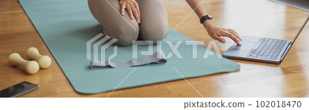 Afro american sporty woman sit on floor and preparing for online fitness class from home Afro american sporty woman sit on floor and preparing for online fitness class from home 102018470