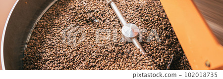 Close up of coffee roasting machine with coffee beans in small coffee manufacturing Close up of coffee roasting machine with coffee beans in small coffee manufacturing 102018735