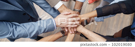 Top view of group coworkers stacked hands together as concept of corporate unity Top view of group coworkers stacked hands together as concept of corporate unity 102019080