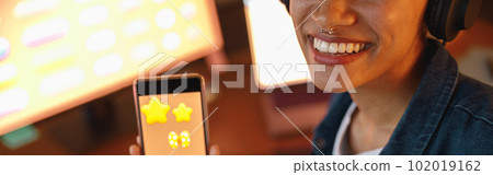 Woman graphic designer is showing smartphone during work day in home office Woman graphic designer is showing smartphone during work day in home office 102019162
