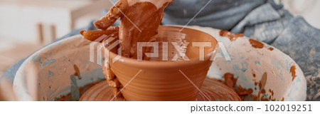 Skillful female potter creating earthen bowl on circle in workroom Skillful female potter creating earthen bowl on circle in workroom 102019251