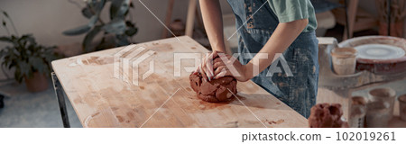 Handmade artist shaping clay while making ceramics in pottery workshop 102019261