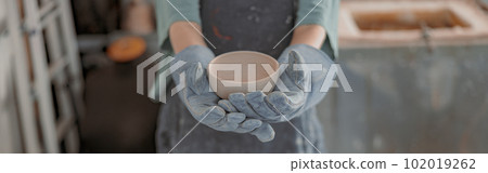 Young female master working with pottery in workroom 102019262