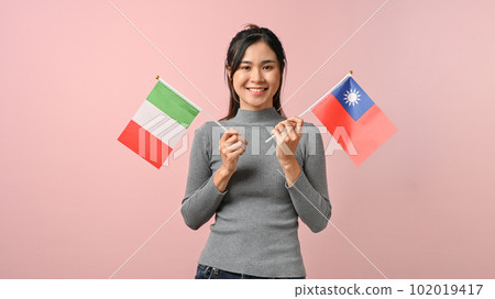 Cute Asian girl showing Italy and Taiwan flag on pink isolated background, education concept. 102019417