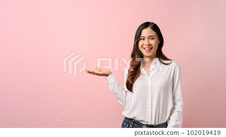Young beautiful Asian woman spreading pointing hands aside on pink isolated background. Young beautiful Asian woman spreading pointing hands aside on pink isolated background. 102019419