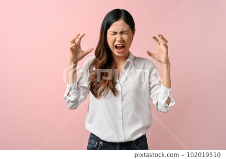 Upset Asian woman having a headache on pink isolated background. 102019510