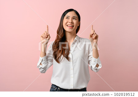 Pretty young woman pointing above her head while standing on pink isolated background. Pretty young woman pointing above her head while standing on pink isolated background. 102019512