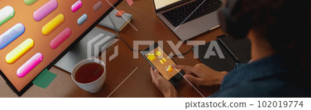 Woman graphic designer is using smartphone during work day in home office Woman graphic designer is using smartphone during work day in home office 102019774