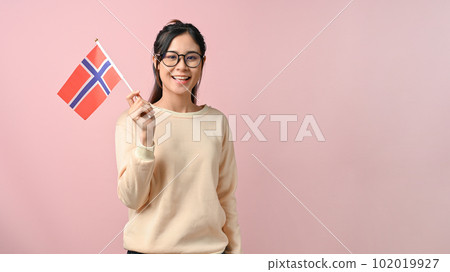 Happy young Asian woman showing a Norway flag on pink isolated background 102019927