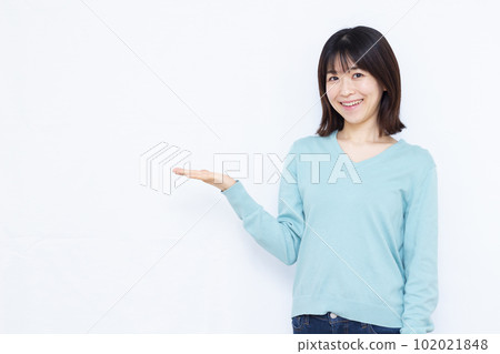 A woman in her thirties making an introduction in front of a white background A woman in her thirties making an introduction in front of a white background 102021848