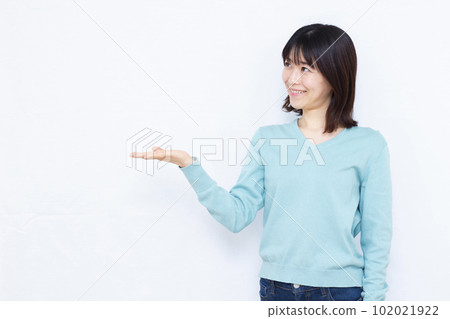A woman in her thirties making an introduction in front of a white background 102021922