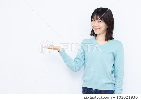 A woman in her thirties making an introduction in front of a white background 102021936