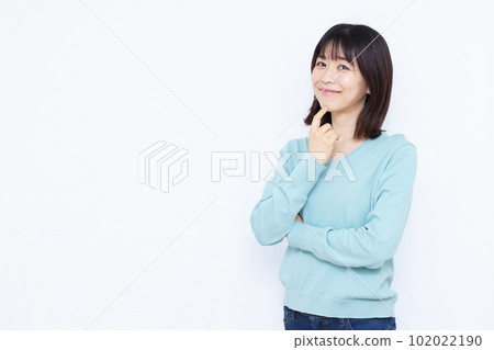 A woman in her thirties making an introduction in front of a white background 102022190
