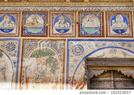Colourful paintings on the outer wall of an old haveli, located in Ramgarh, Shekhawati, Rajasthan, India 102023657