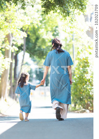 Parent and child walking hand in hand Back view 102023709