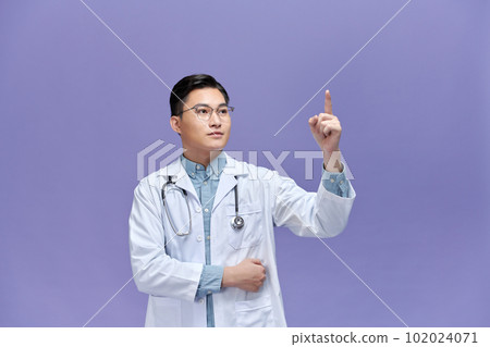 smiling male doctor in white coat pointing finger up smiling male doctor in white coat pointing finger up 102024071
