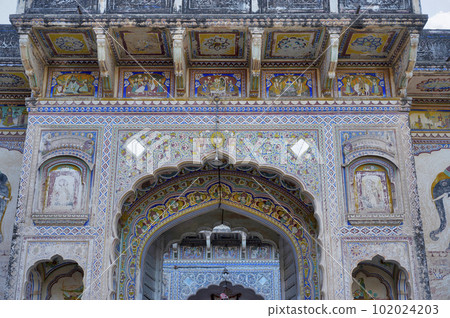 Colourful paintings and mirror work at the entrance gate of an old haveli in Shekhawati. Marwari merchants constructed grand havelis in the Shekhawati region dated 17th to 19th centuries richly 102024203