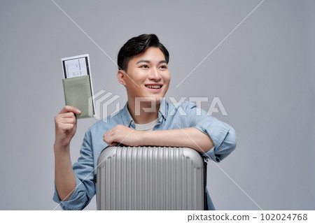 Young asian handsome man isolated on white background in vacation with suitcase and passport Young asian handsome man isolated on white background in vacation with suitcase and passport 102024768