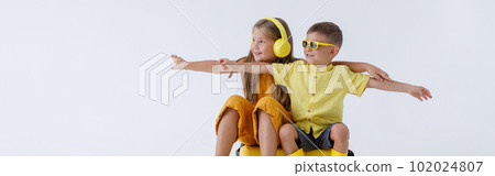 Adorable little girl and boy sitting on travel bag 102024807