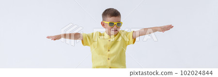 Adorable little boy sitting on yellow travel bag Adorable little boy sitting on yellow travel bag 102024844