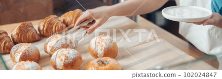 Female hand taking pastry from showcase in cafeteria 102024847