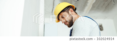 Male worker professional electrician in uniform installing electrical outlet in apartment after renovation work Male worker professional electrician in uniform installing electrical outlet in apartment after renovation work 102024914