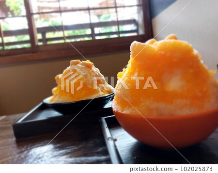 在一家古老的私人咖啡館享用芒果和柑橘刨冰 102025873