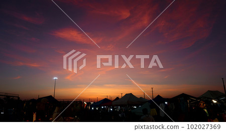 Dramatic sky with silhouette of night market 102027369