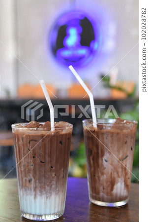 Chocolate milk in glass on wooden table Chocolate milk in glass on wooden table 102028782