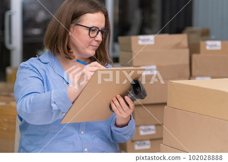 online store concept. SME businesswoman who sells products online, tracking orders and managing packaging materials for her small business 102028888