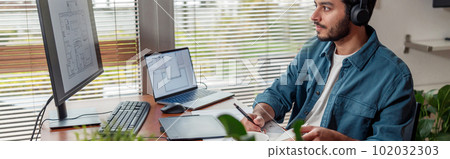 indian male designer in headphones works in home office drawing on graphic tablet indian male designer in headphones works in home office drawing on graphic tablet 102032303