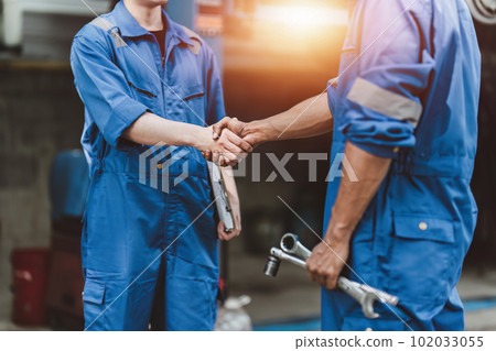 Expert auto mechanic handshake and working together at garage. automobile car concept 102033055