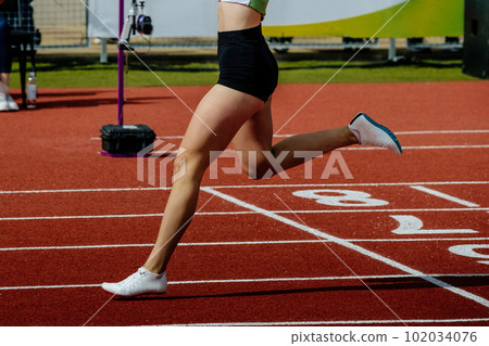 young female runner winner sprint race running finish line, summer athletics championships young female runner winner sprint race running finish line, summer athletics championships 102034076