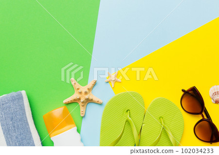 Beach accessories straw hat and seashell on colored table. Summer concept background 102034233