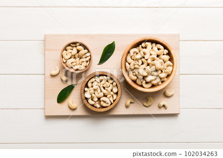 cashew nuts in wooden bowl on table background. top view. Space for text Healthy food 102034263