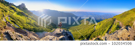 Young woman and her dog on mount Vuhaty Kamin. Panorama. Chornohora ridge, Carpathian mountains, Ukraine. Young woman and her dog on mount Vuhaty Kamin. Panorama. Chornohora ridge, Carpathian mountains, Ukraine. 102034506